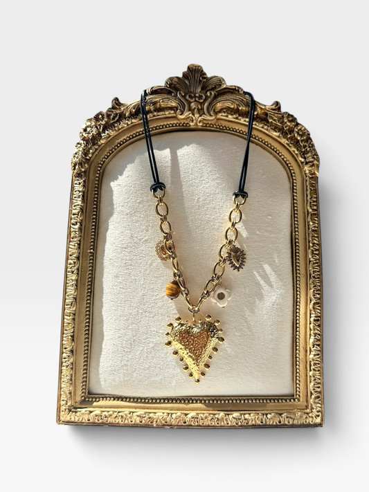 TheConsignmentBar 18K gold heart charm necklace featuring a textured heart pendant, flower, and stone accents on a cord