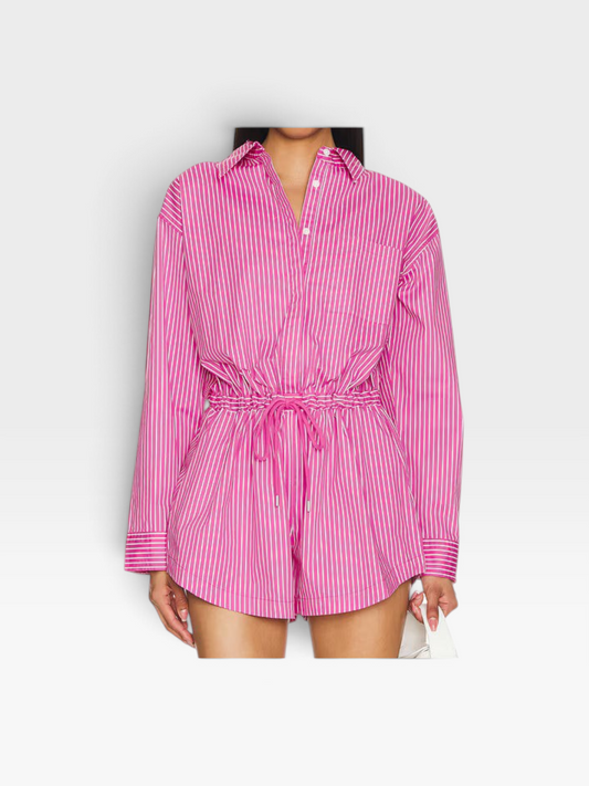 Model wearing a pink and white striped long-sleeve button-down romper by TheConsignmentBar with a drawstring waist.