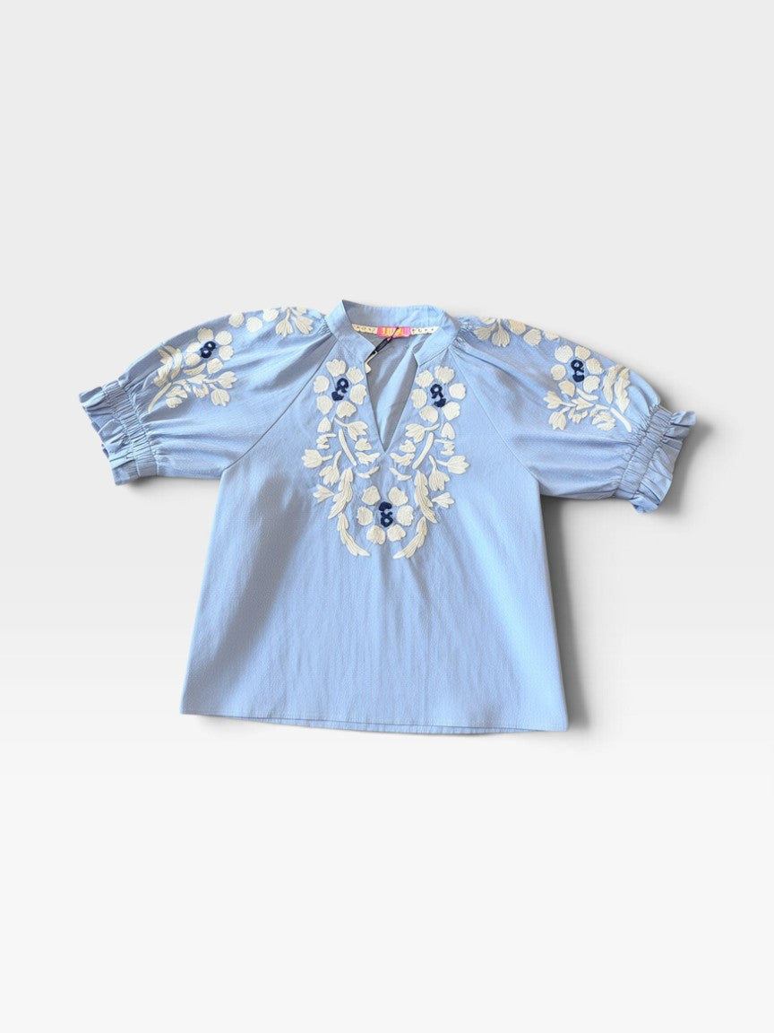 TheConsignmentBar THML light blue blouse with white floral embroidery, split neckline, and ruffled puff sleeves.